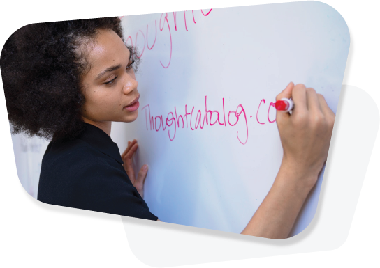 Image of a young woman writing on a whiteboard in a classroom.