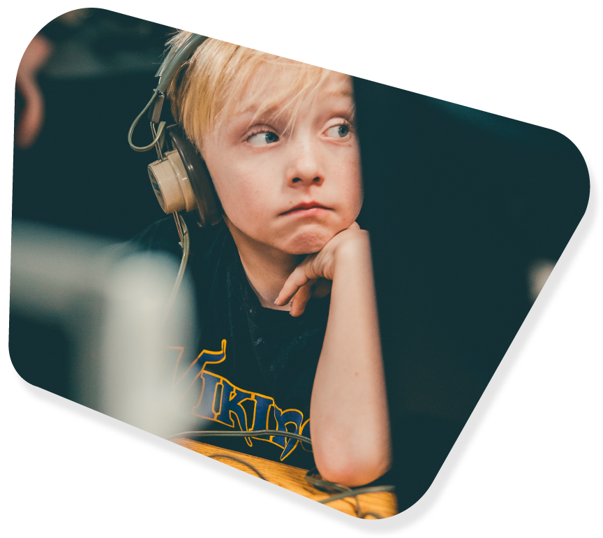 An image of a boy wearing headphones, distracted by something happening across the room.