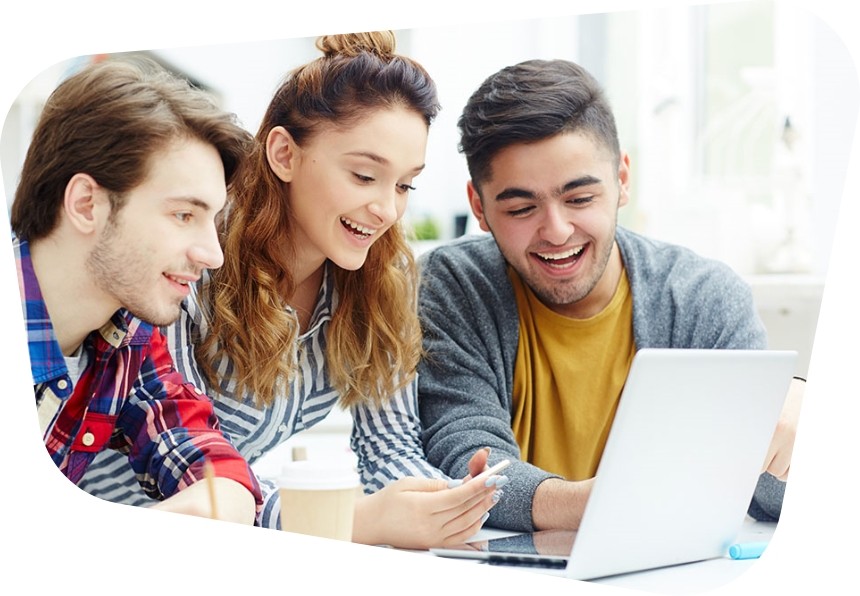 A group of young people gather around a laptop together, smiling at something on the screen.