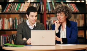 Teach and student review an AP curriculum on a laptop