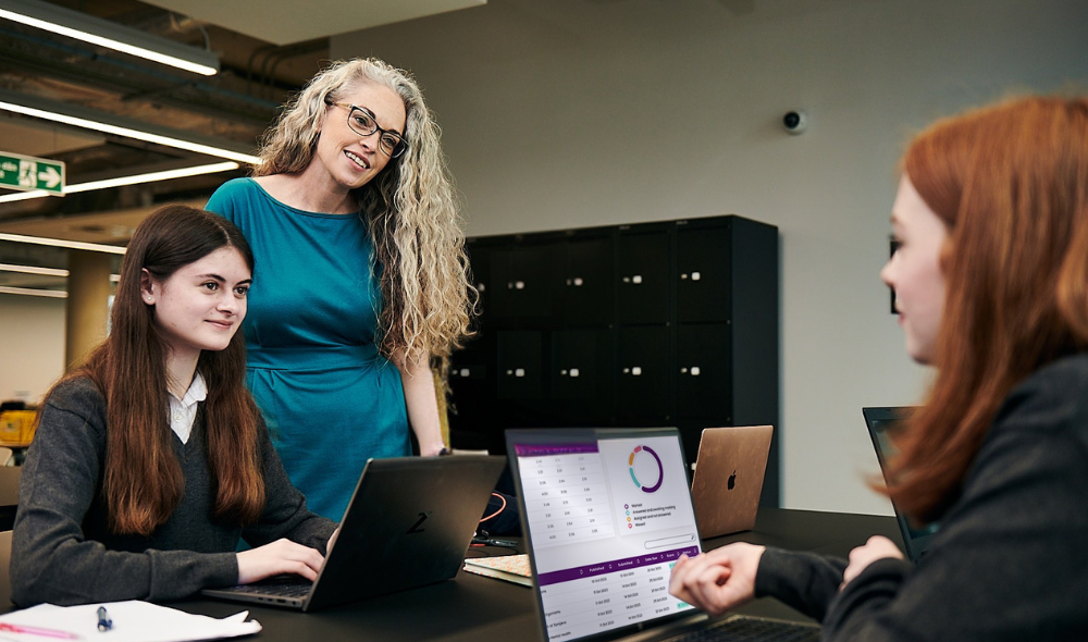 Two students study online with support of a teacher